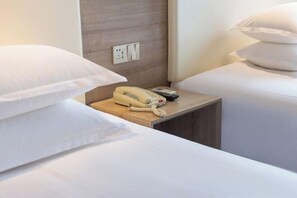 A hotel room with two beds, white bedding, a bedside table with a telephone, and a wall socket. - HanTing Premium Hotel (Hangzhou Linping Intime City Subway Station) (Hangzhou)
