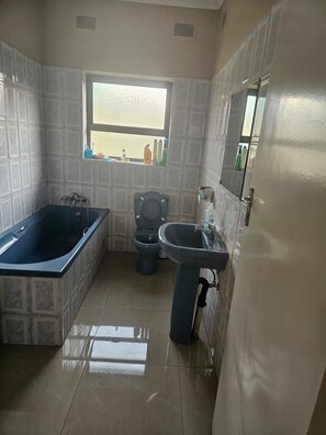 A bathroom with a bathtub, toilet, and sink.