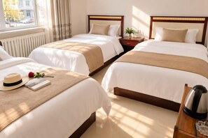 A hotel room with two beds, a bedside table with a lamp, a window with curtains, and a view of the outside. - Aershan Xinda Hotel (Arxan)