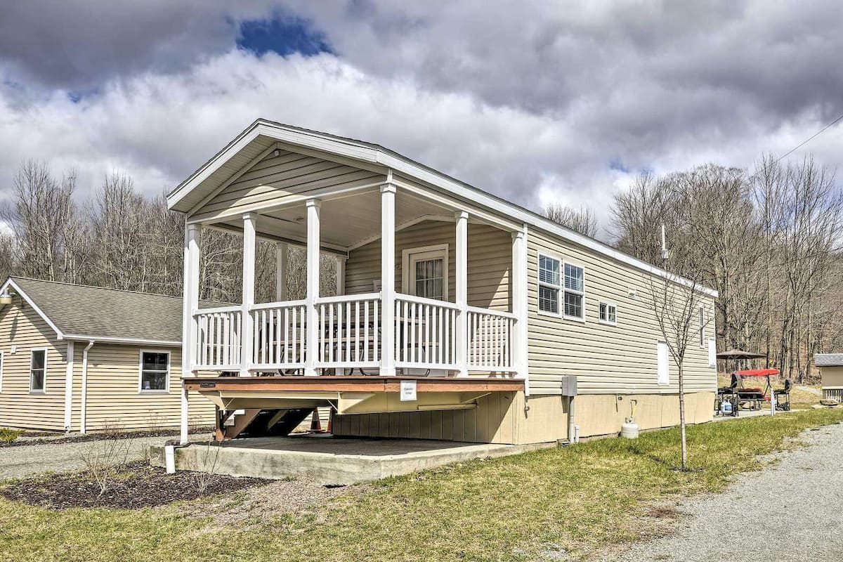 A single-story mobile home with a porch and a covered outdoor area.