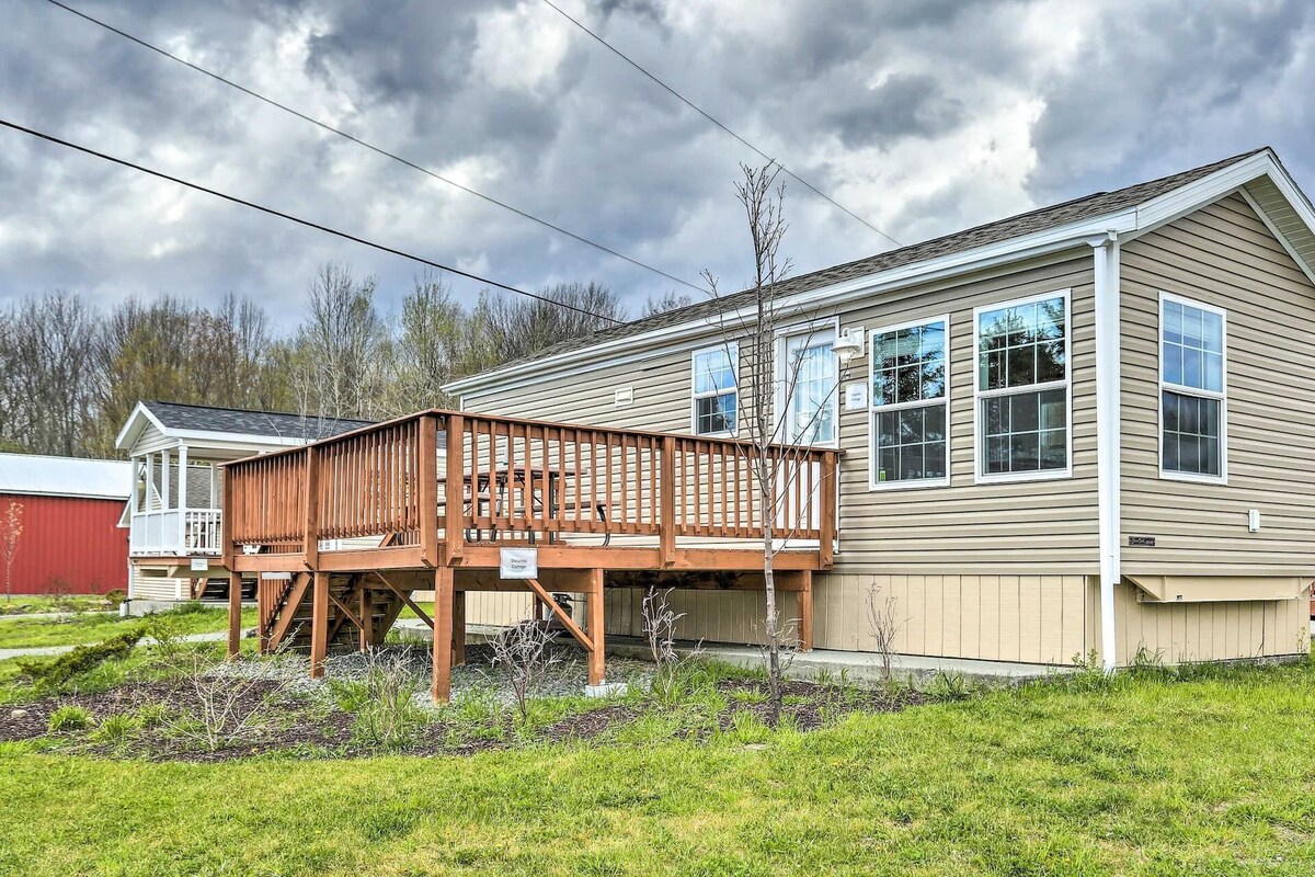 A two-story house with a wooden deck and a covered porch.