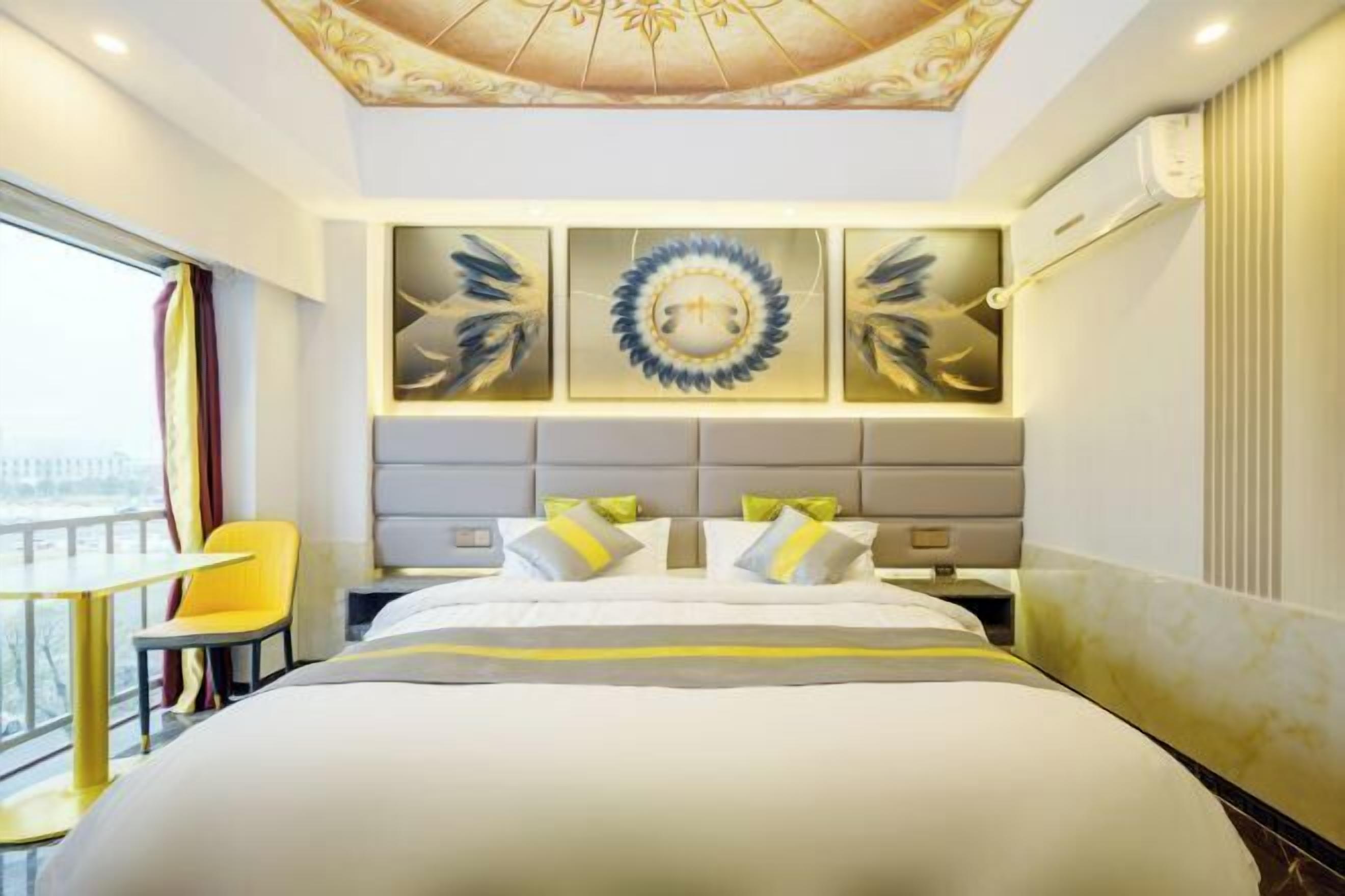 Habitación de hotel con una cama grande, una silla, vistas al balcón y decoración en la pared.