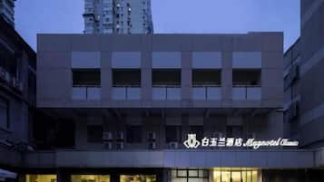 A hotel building with a modern facade, large windows, and a visible logo.