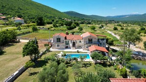 A large villa with a swimming pool, surrounded by lush greenery and hills. - Villa Bosnjak with a private pool (Osoje)