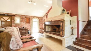 A spacious living room with a fireplace, wooden furniture, and a staircase. - Villa Bosnjak with a private pool (Osoje)