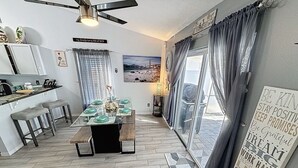 A modern kitchen with a dining area, a large window with curtains, and a motivational quote on the wall. - 4m Disney : Private Pool, Hot Tub, Game Room & Fast WiFi, pets, Guests favorite (Kissimmee)