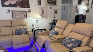 A modern living room with a beige sectional sofa, a small side table, and a blue rug. - 4m Disney : Private Pool, Hot Tub, Game Room & Fast WiFi, pets, Guests favorite (Kissimmee)