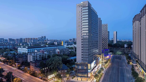 A high-rise hotel with a modern design, featuring a prominent vertical sign with the hotel name. - Microtel By Wyndham Changsha South Railway Station (Changsha)