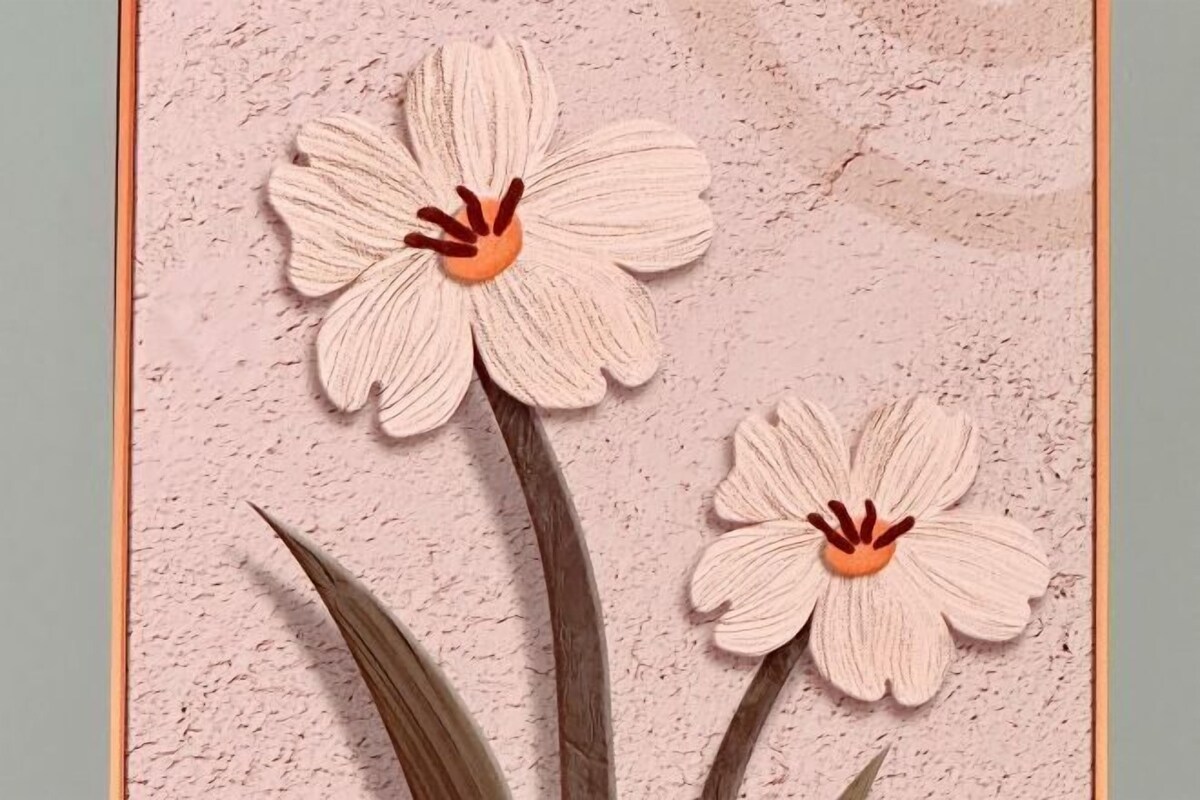 Two artificial flowers on a textured wall.