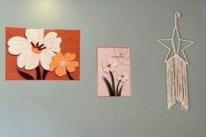 Two framed artworks and a macramé star decoration on a wall. - Qiaoyu Inn (Zhoushan)