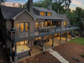 A two-story house with a covered patio, outdoor seating, and a hot tub. - Lake Oconee Waterfront, Dock & Hot Tub (Eatonton)