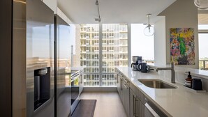 Una cocina moderna con un amplio ventanal, electrodomésticos de acero inoxidable y un diseño minimalista.