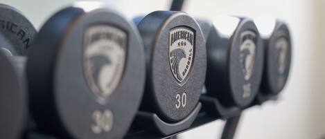 A row of dumbbells with the brand "AMERICAN" and weight markings.