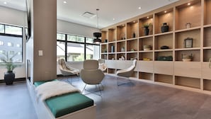 A modern interior with a long bench, two chairs, and a wooden shelving unit with various decorative items. - The Crescent (Rossland)
