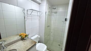 Une salle de bain avec des toilettes, un lavabo et une douche.
