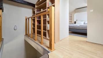 Ein Zimmer mit einer Holzhülle, einem Bett und einer Tür zu einem weiteren Bereich.