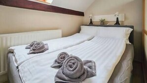 A bedroom with two beds, a skylight, a radiator, and a bedside table with a lamp. - IMCT - Appartamento Quattroporte (Budapest)