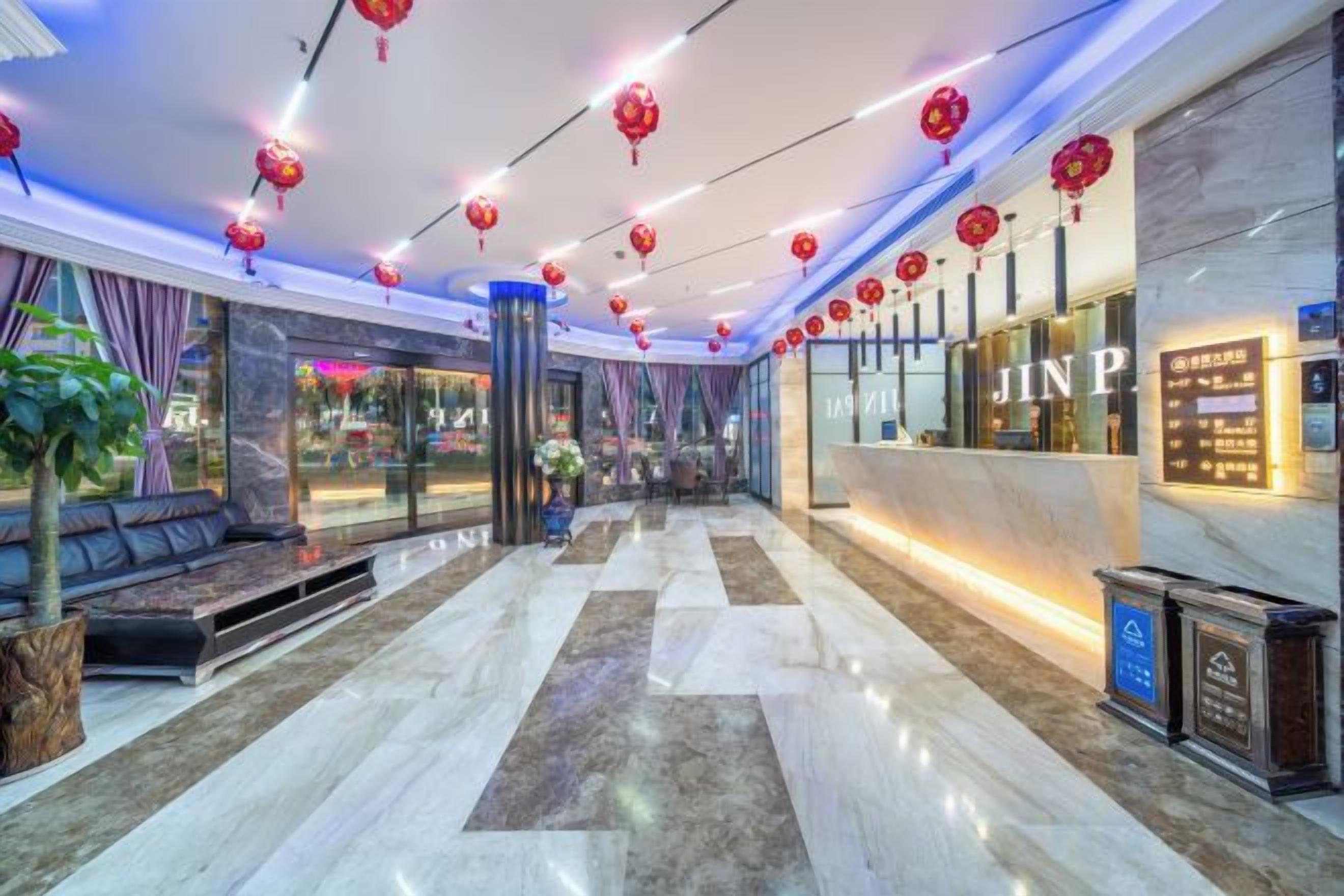 Un hall d’hôtel comprenant un comptoir d’accueil, un espace salon et une grande fenêtre.