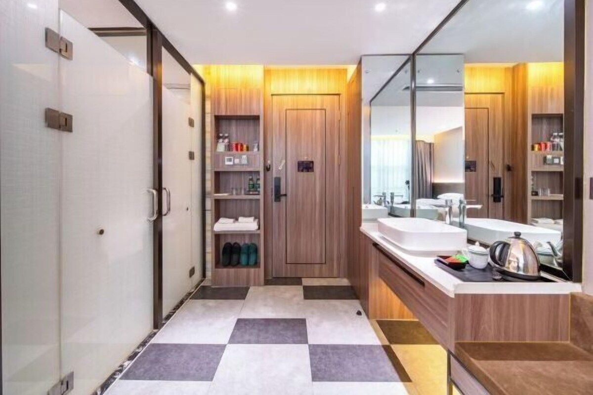 A modern bathroom with a checkered floor, wooden vanity, and a large mirror.