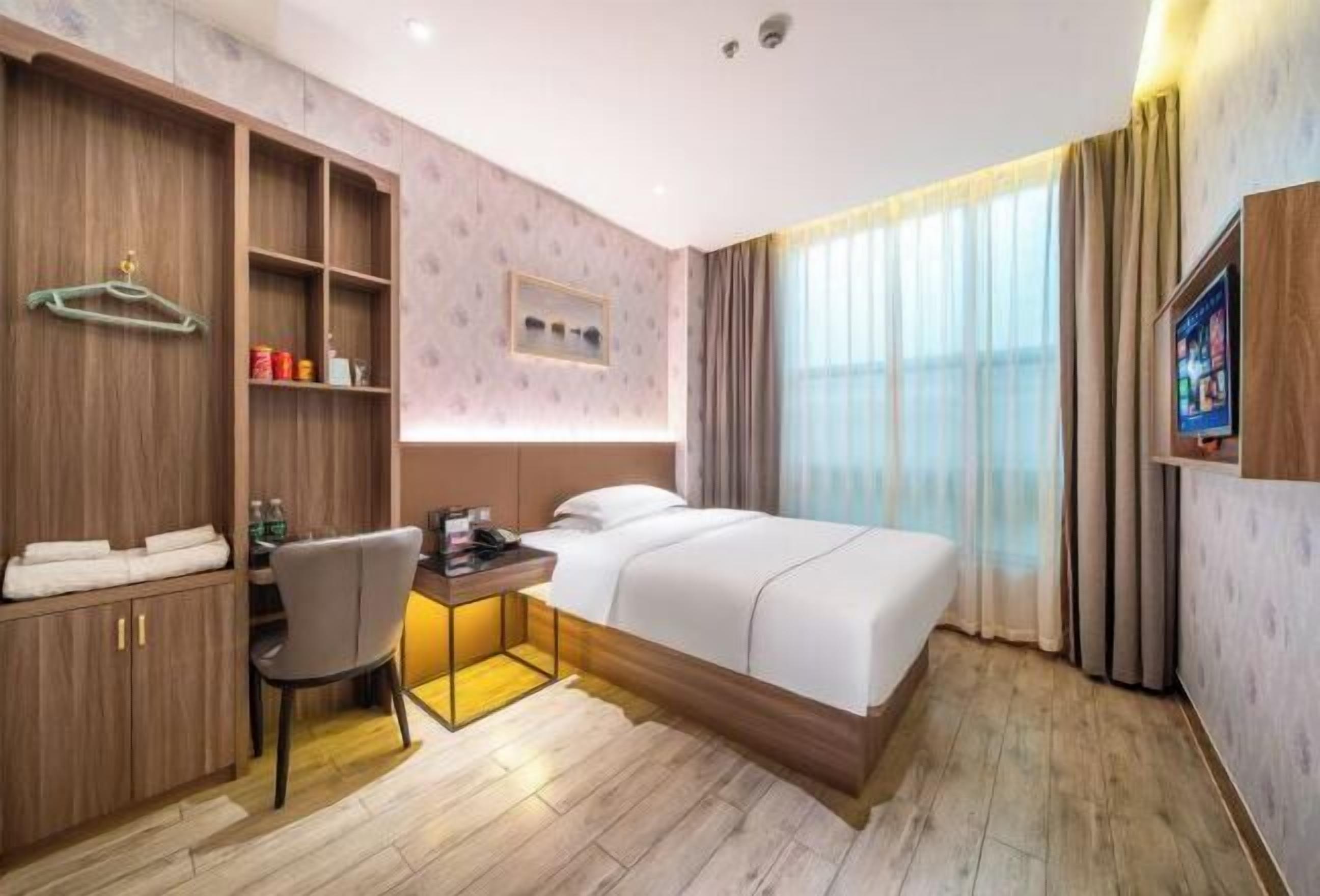 Une chambre d’hôtel équipée d’un lit, d’un bureau, d’une chaise, d’une télévision et d’une armoire.