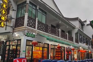 A traditional building with a balcony and signage indicating a business establishment. - Caifu Business Hotel (Hengyang)