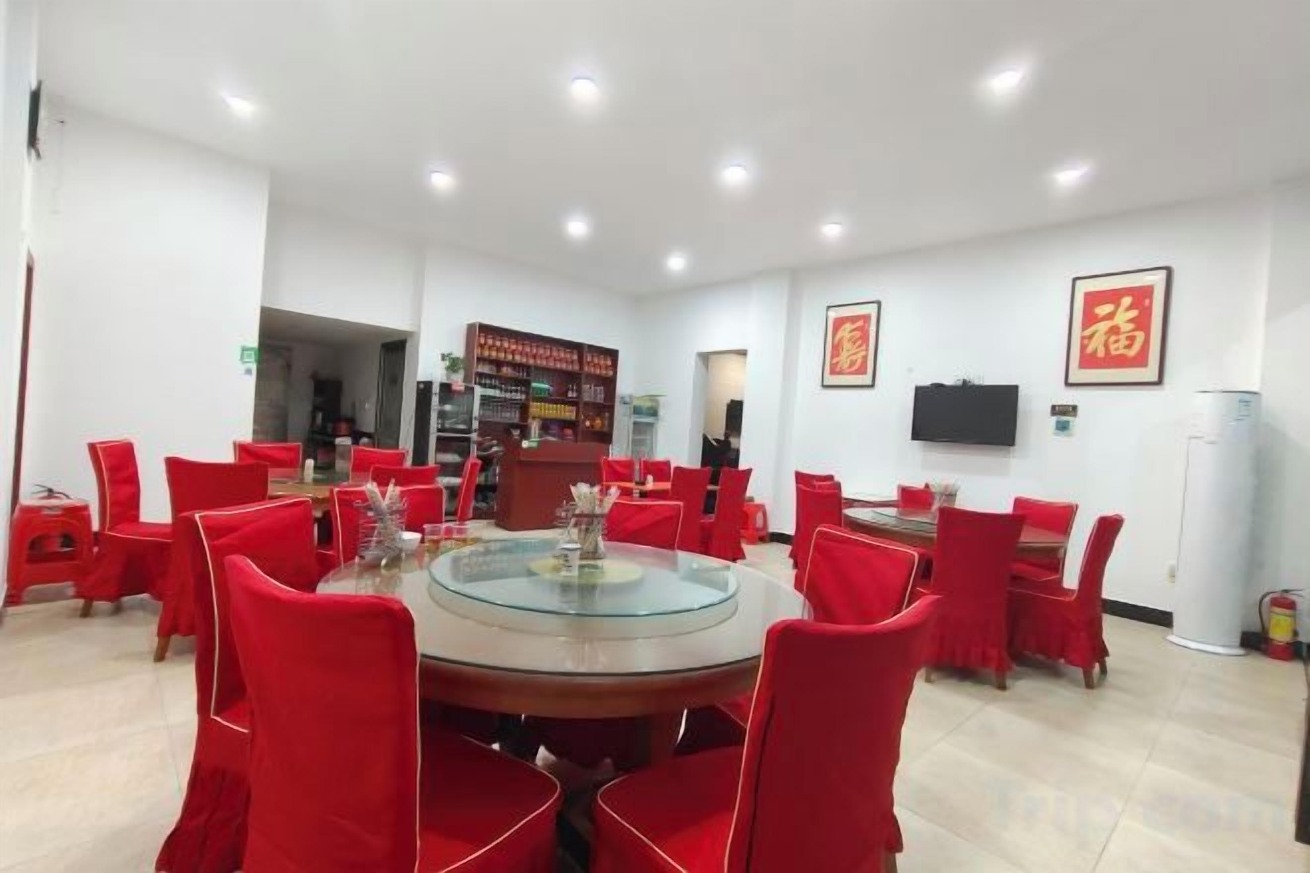 A conference room with a round table, red chairs, a television, and a vending machine.