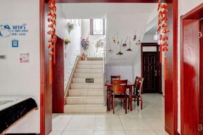 A staircase leading to a dining area with a table and chairs, a wooden door, and a sign indicating the WiFi network. - Beijing Chenshuang Restaurant (Beijing)