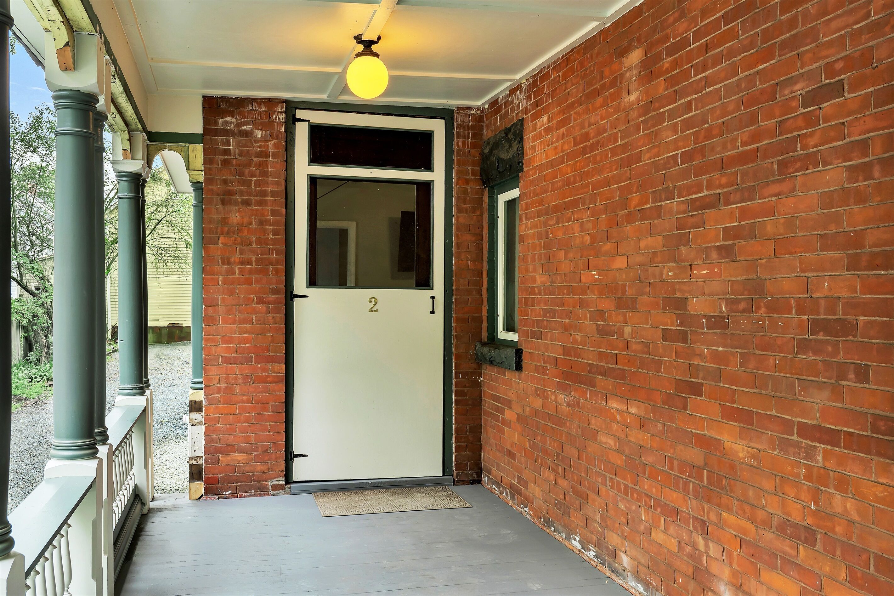 A brick building with a white door and a small window.