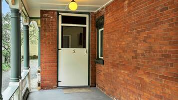 A brick building with a white door and a small window.