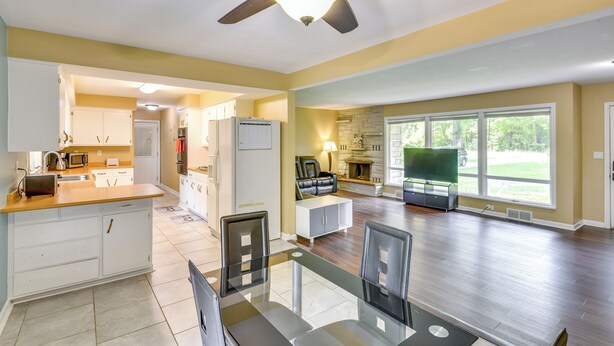 A spacious kitchen with a dining area, a fireplace, and large windows. - 5 Mi to Warren Dunes - Secluded Sawyer Home! (Sawyer)
