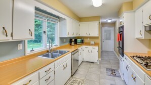 A kitchen with white cabinets, a microwave, a sink, and a stove. - 5 Mi to Warren Dunes - Secluded Sawyer Home! (Sawyer)