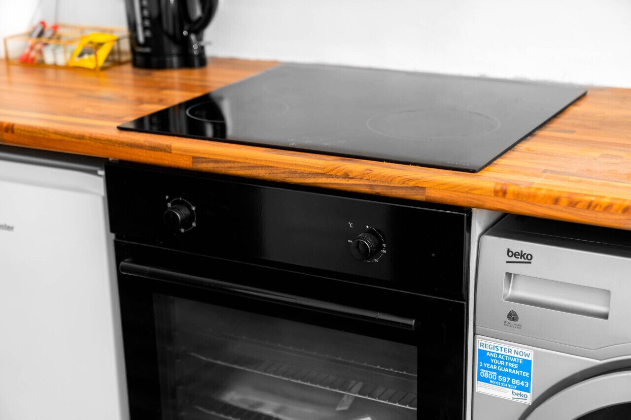A kitchen with a black oven and a wooden countertop.