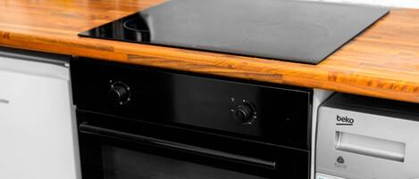A kitchen with a black oven and a wooden countertop.