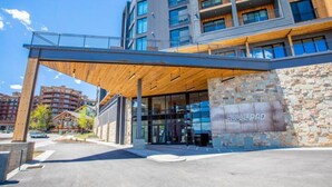 A modern hotel entrance with a covered walkway, stone facade, and a sign reading "HOTELPAD". - Fun in Canyons Village-Pet friendly at Canyons Resort + Pool, Gym, and Game Room (Park City)