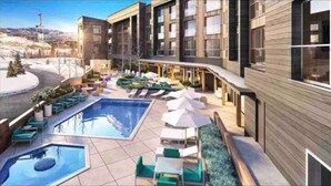 A modern hotel with a pool area, outdoor seating, and a view of the surrounding landscape. - Fun in Canyons Village-Pet friendly at Canyons Resort + Pool, Gym, and Game Room (Park City)