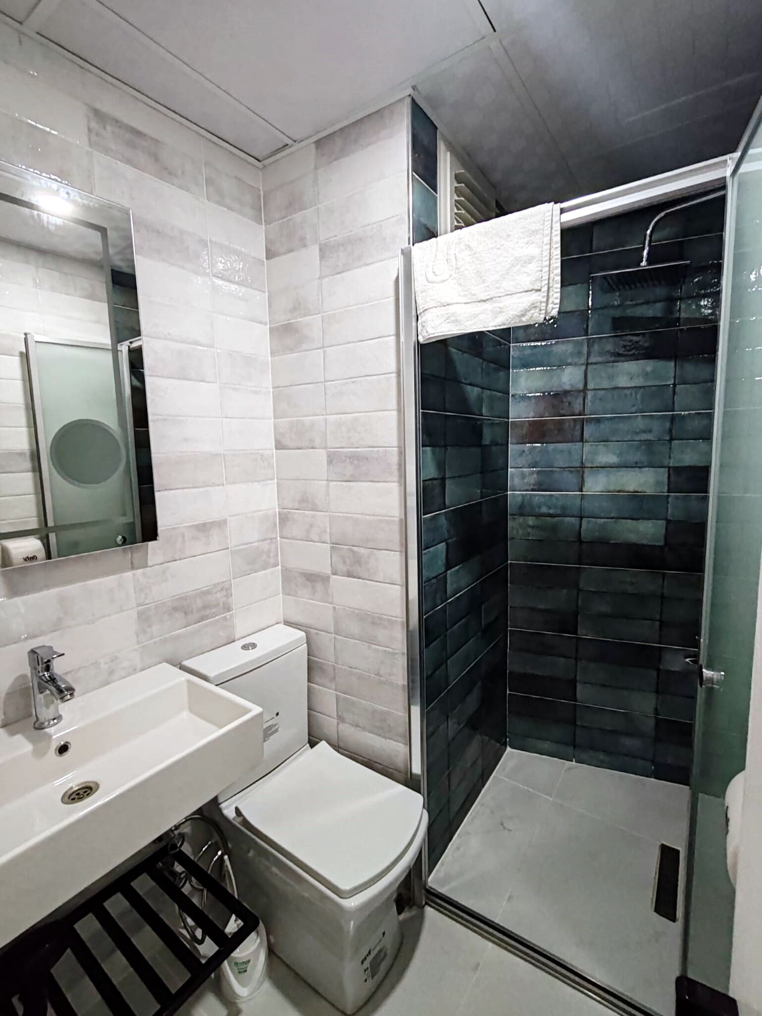 Uma casa de banho moderna com lavatório branco, sanita e cabine de duche em vidro.