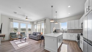 A modern kitchen with white cabinets, a central island, and pendant lighting. - Bright, Spacious 2BD in heart of Tampa | Free Prkg (Tampa)