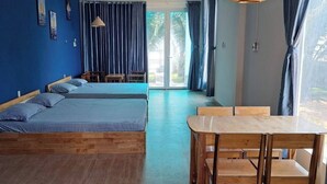 Una camera moderna con un letto, un tavolo da pranzo e vista attraverso una porta vetrata.
