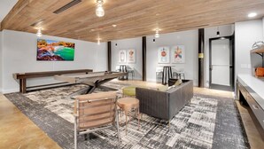 A modern interior with a wooden ceiling, a dining area with a bench, a sofa, and a coffee table. - Huge, Open Loft | Arts District | 5 mins to DT GVL (Greenville)