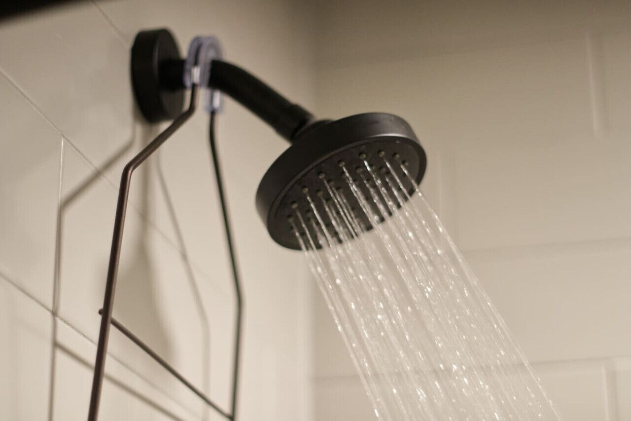 A showerhead with water flowing from it.