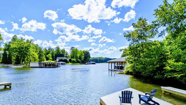 A lakeside dock with chairs, a gazebo, and a house in the background. - Lakefront Lake Anna, Hot Tub, Pool, Beach (Mineral)