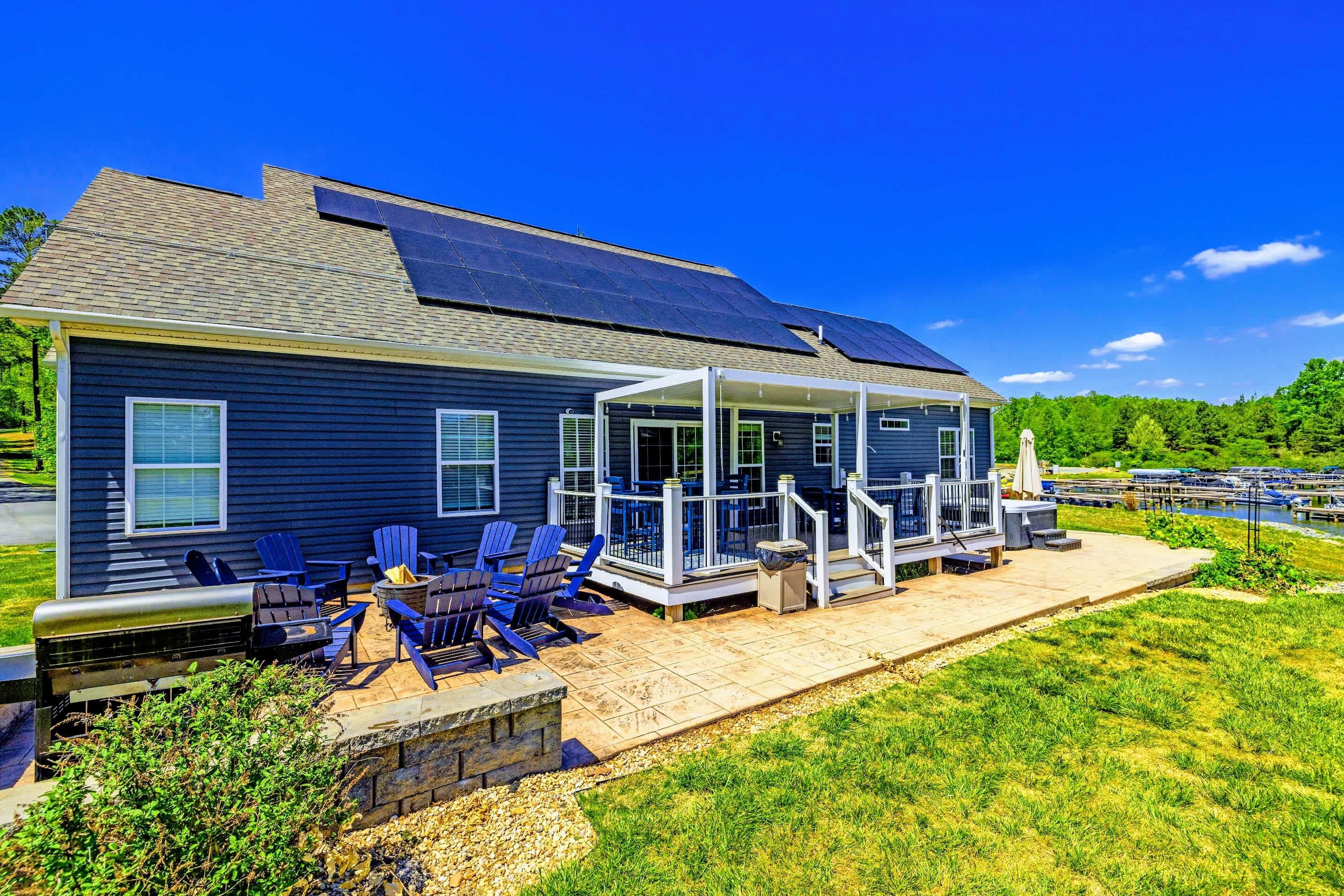 Back Deck & Fire Pit - Stamped patio with Adirondacks circled at the fire pit, marina views beyond.