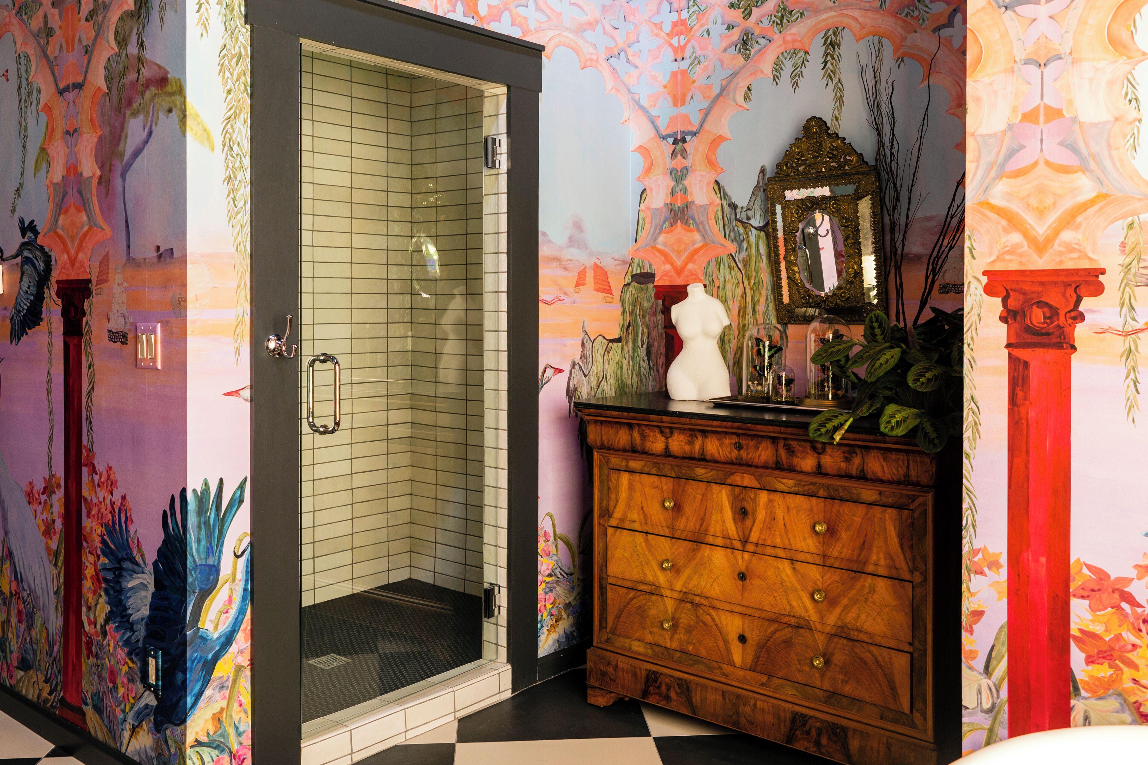 Baño con ducha, cómoda de madera y espejo.