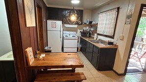 Eine Küche mit Holztisch, Kühlschrank, Herd und Mikrowelle.