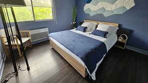 A modern bedroom with a large bed, a desk, and a chair. - Quiet 2B/1B Downtown Condo, Hills View, Bright, Spacious, Recently Remodeled (Aurillac)