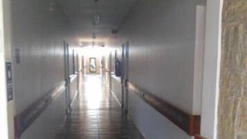 A long, narrow hallway with patterned tile flooring and white walls.