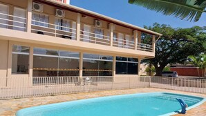 Un edificio de dos pisos con una piscina delantera.