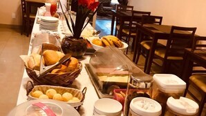 Una mesa de buffet con diversos alimentos y recipientes.
