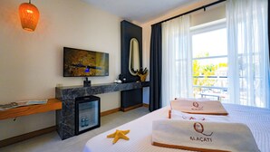 A hotel room with a bed, a desk, a television, a minibar, and a balcony with curtains. - Q Alacati Otel (Cesme)