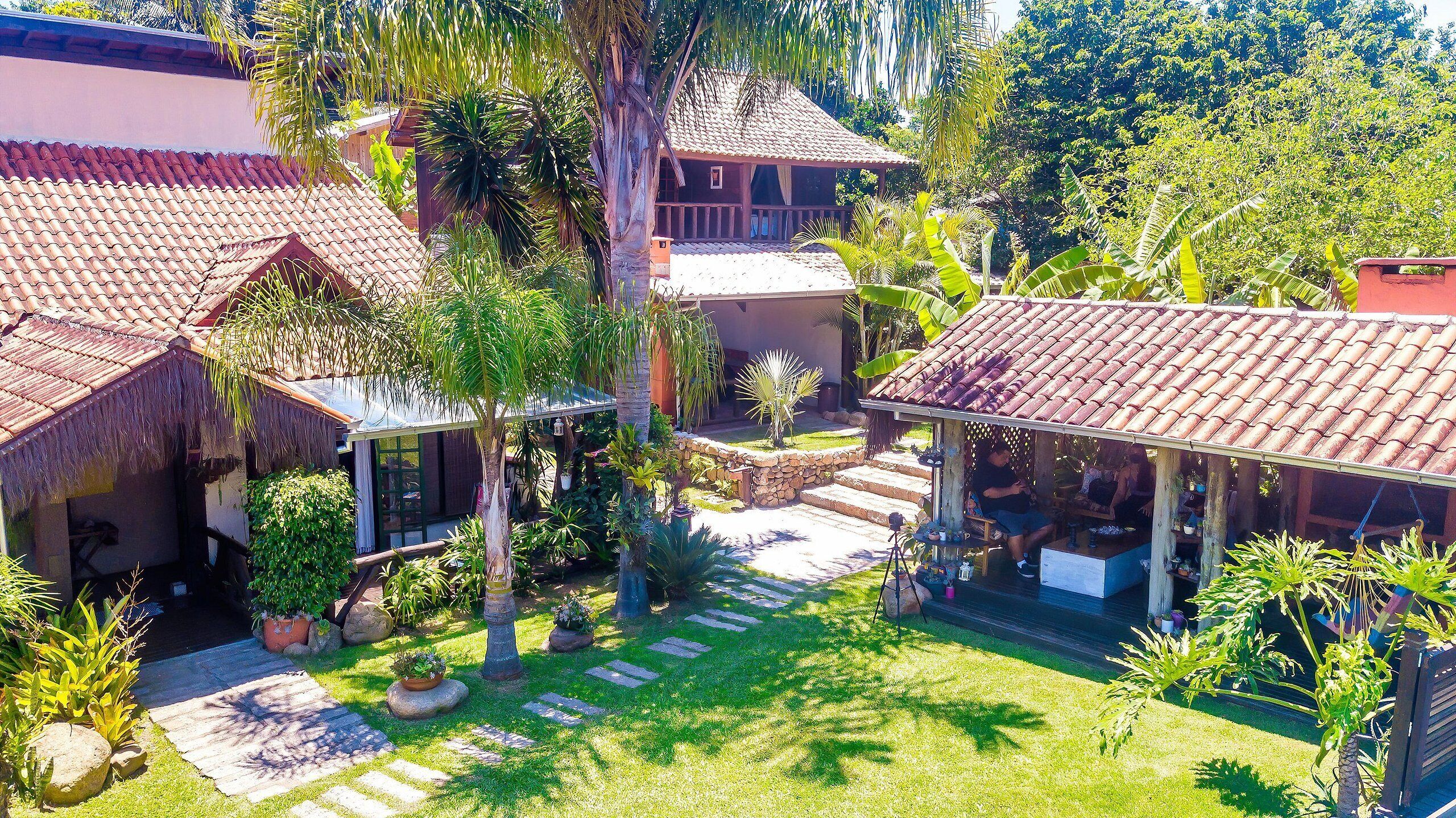 A tropical resort with multiple buildings, a stone pathway, and lush greenery.